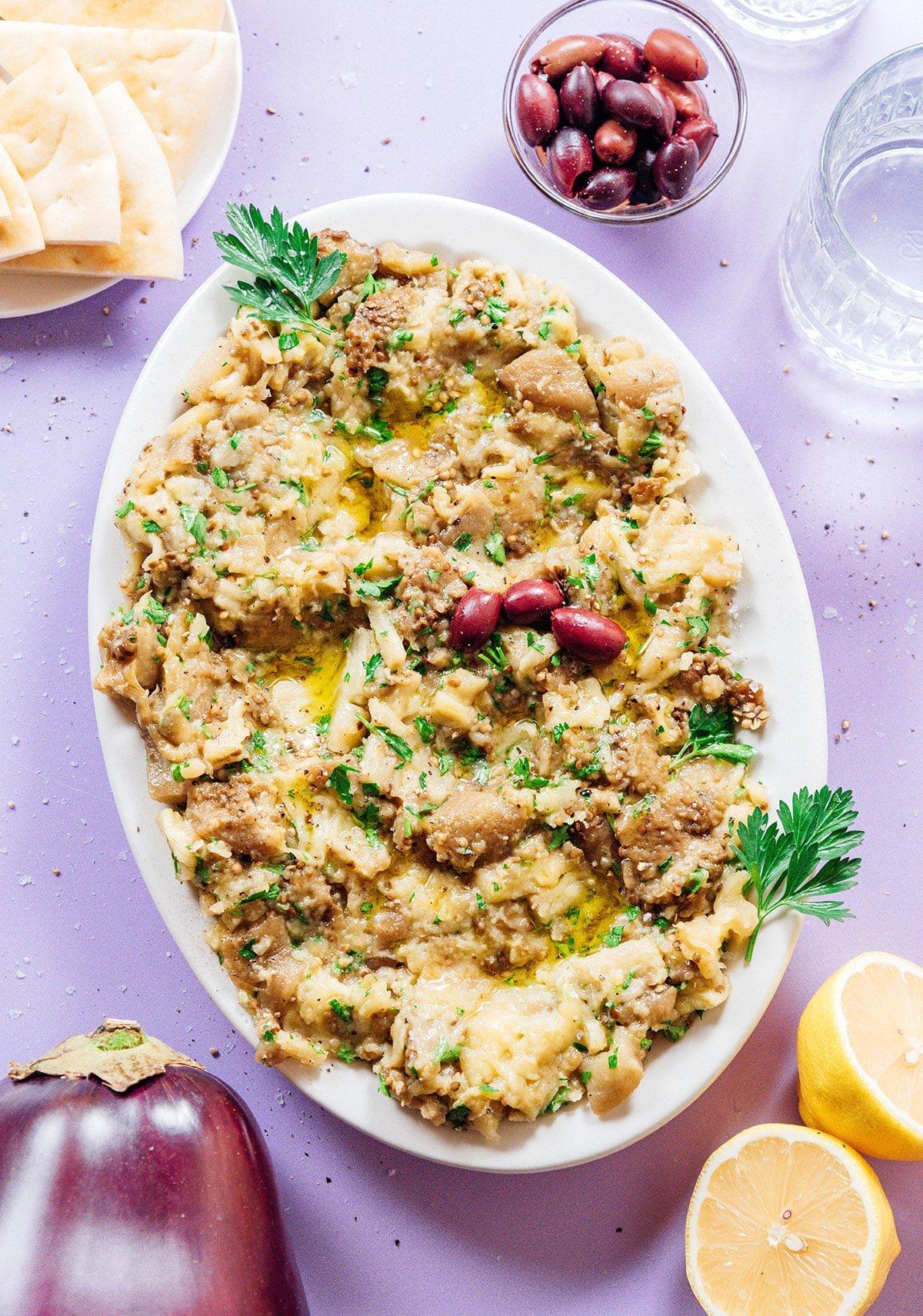 Griechischer Auberginen-Dip (Melitzanosalata) 2 Große weiße Platte mit griechischem Auberginen-Dip und Oliven.