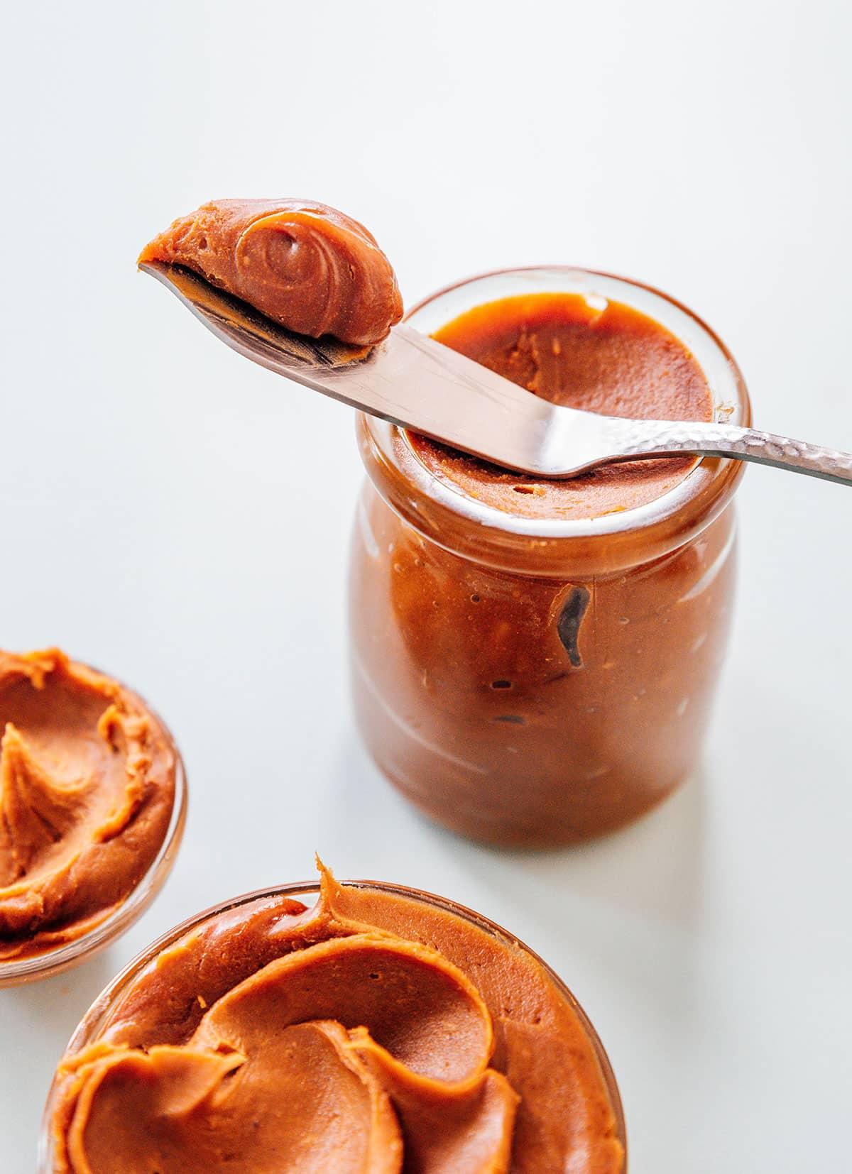 Wie man Spekulatius-Kekscreme herstellt 2 Ein Glas hausgemachte Spekulatius Keksbutter mit einem Streichmesser.