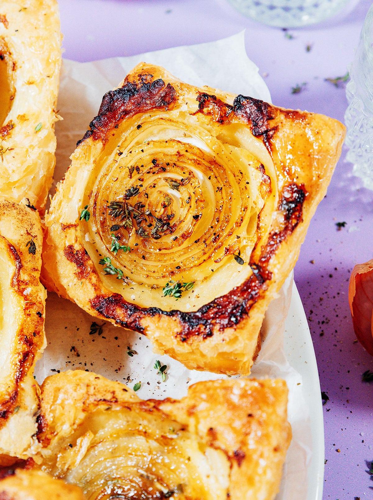**Gestürzte Zwiebeltarte mit Brie** 2 Zwiebeltarte auf einem Teller.