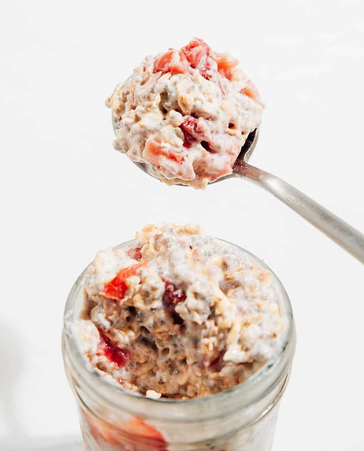 Cremige Erdbeer Overnight Oats (5 Minuten) 2 Löffel voller Erdbeer Overnight Oats, bereit zum Genießen.