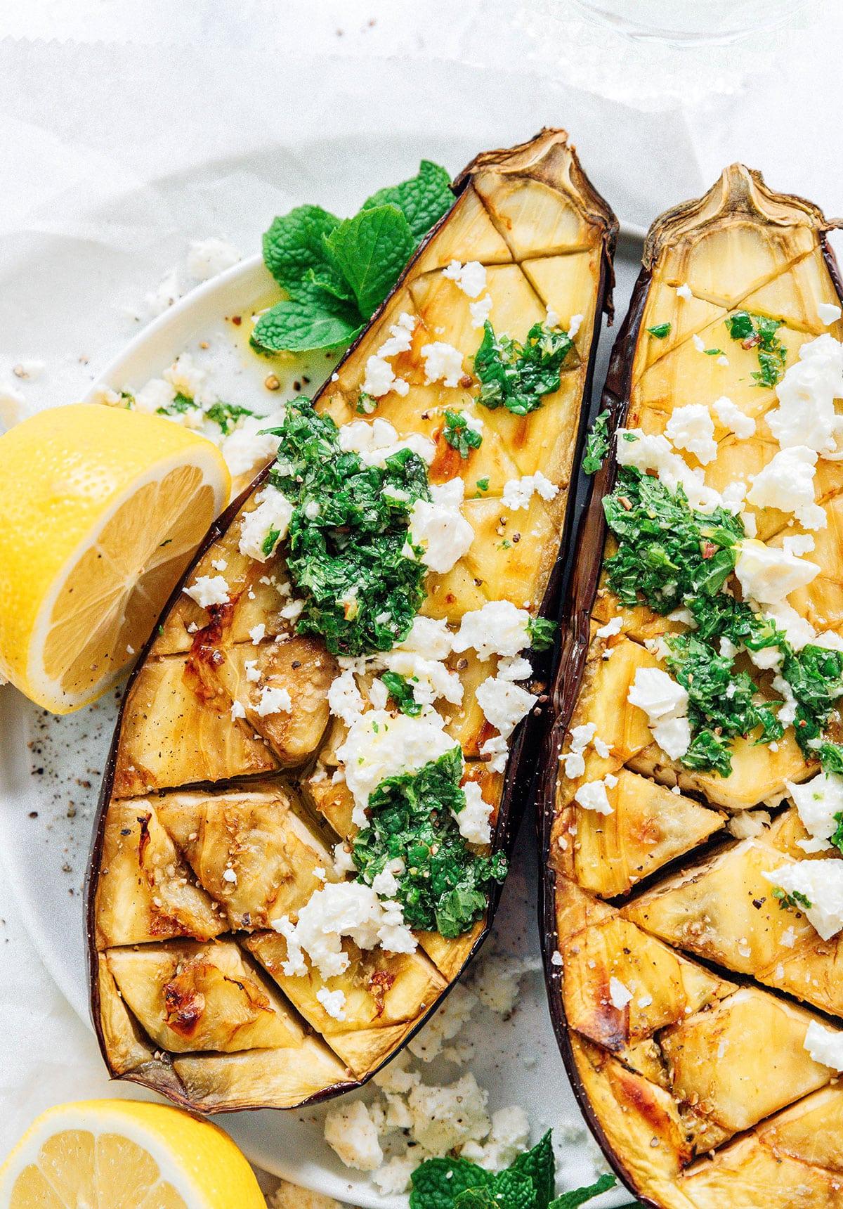 Geröstete Aubergine mit Feta-Minz-Soße 2 Geröstete Aubergine aufgeschnitten mit Feta und Minze.