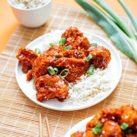 General Tso's Blumenkohl auf einem Teller mit Reis und Frühlingszwiebeln