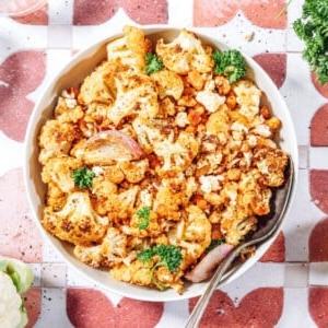 Gerösteter Blumenkohlsalat mit knusprigen Bohnen 11 Gerösteter Blumenkohlsalat in einer weißen Schüssel mit einem Löffel.