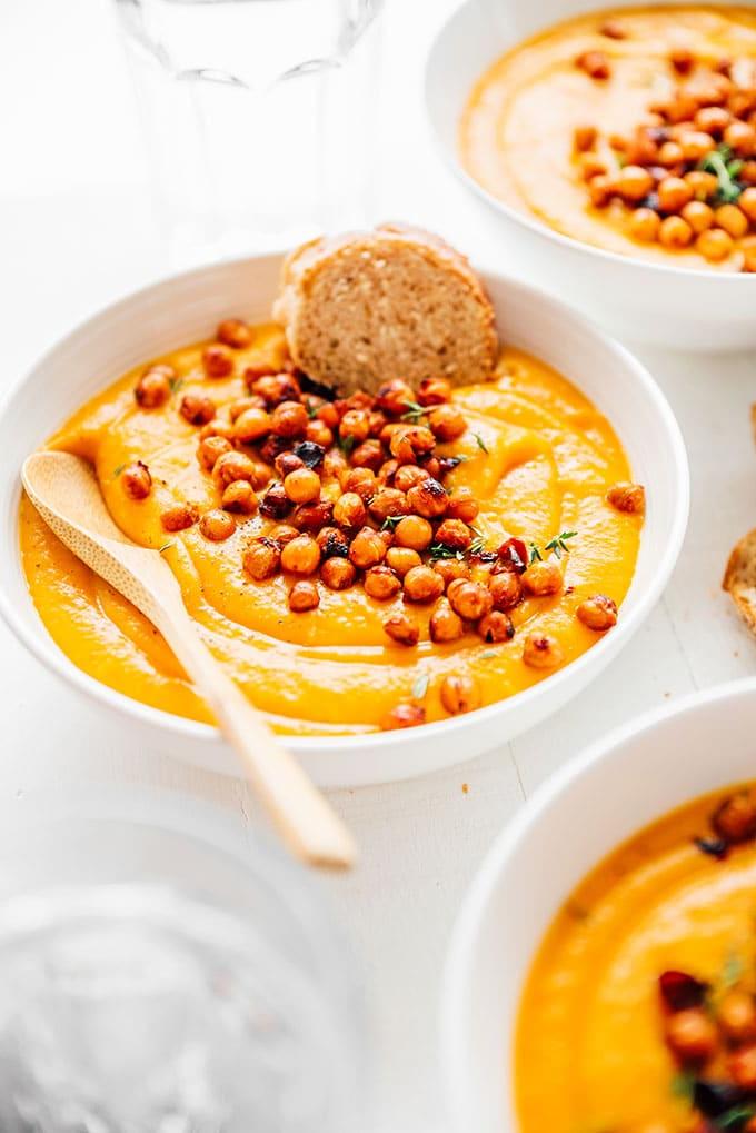 Kürbissuppe in einer Schale mit Kichererbsen als Topping und Thymian
