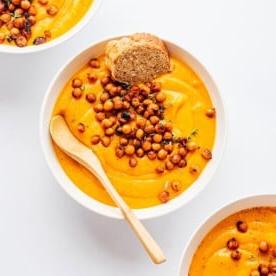 Kürbiscremesuppe in einer Schüssel mit Kichererbsen als Topping