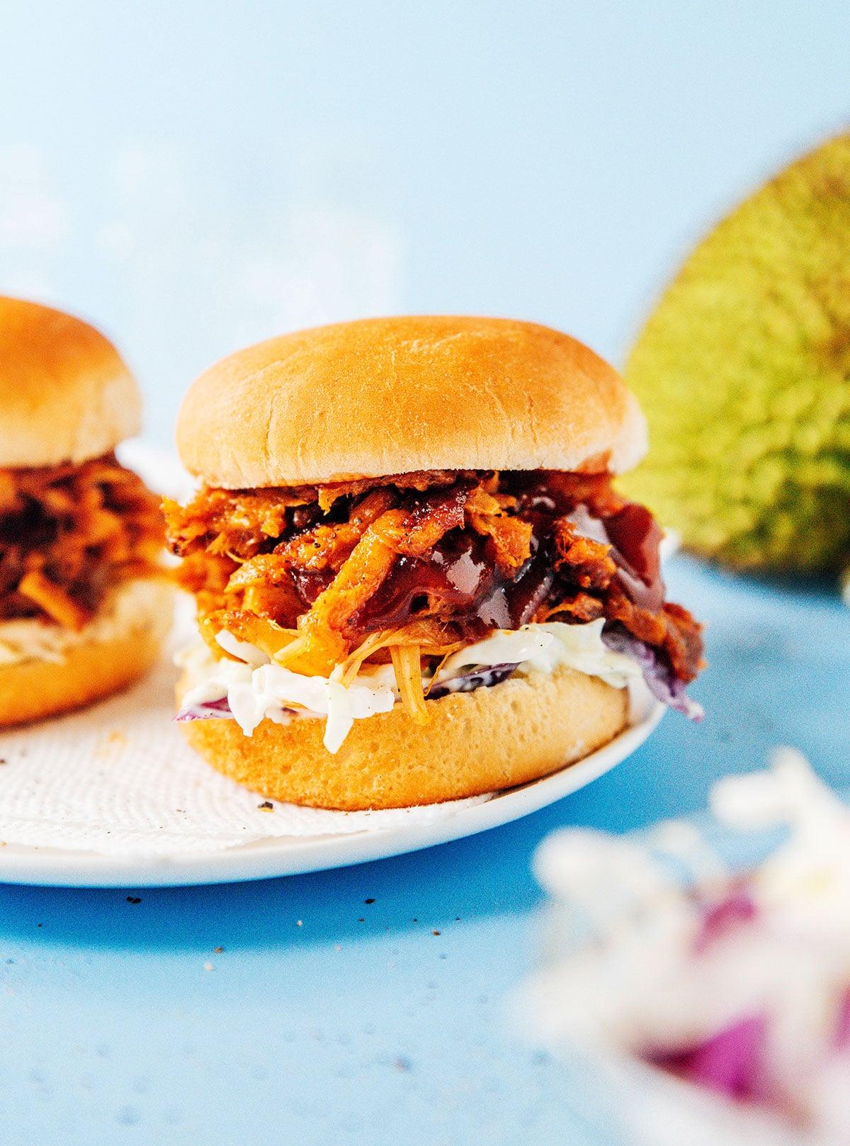 BBQ Jackfrucht Pulled Pork (Fertig in 30 Minuten) 12 Ein Detailbild eines BBQ Jackfrucht Sliders mit Krautsalat und heruntertropfender BBQ-Sauce.