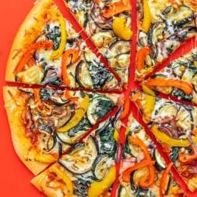 Vegetarische Pizzastücke auf rotem Hintergrund.