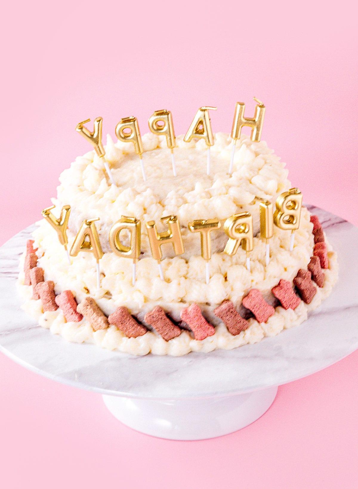 Einfacher Hundegeburtstagskuchen (Mit Kartoffelpüree-Topping!) 13 Ein Hundekuchen mit Kerzen, die Happy Birthday sagen