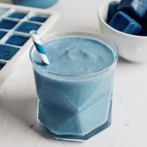 Smoothie-Würfel (Evive-Kopie) 13 Ein blauer Smoothie in einem Glas, garniert mit frischen Früchten.