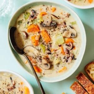 Cremige Vegane Wildreissuppe 13 Eine Schüssel Wildreissuppe mit einem Löffel.