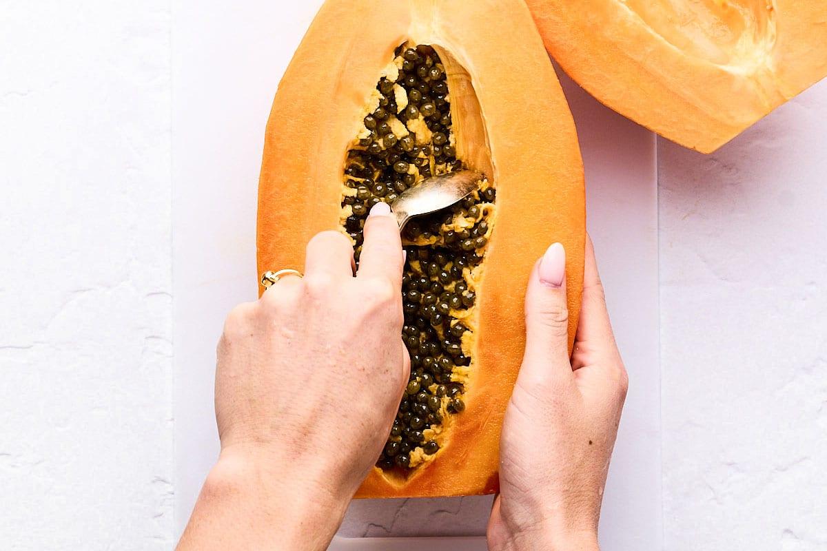 Kerne aus Papaya schöpfen.