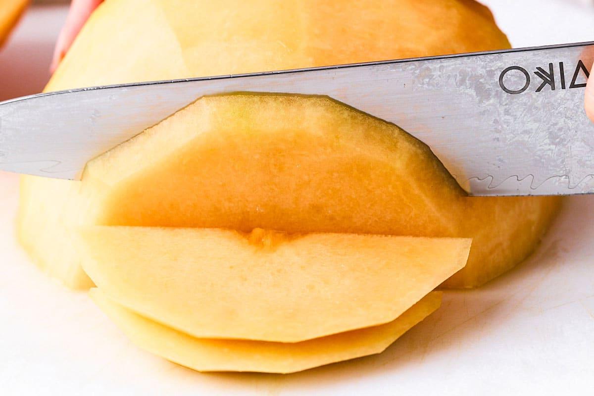 Eine Kantalupemelone in Scheiben schneiden.