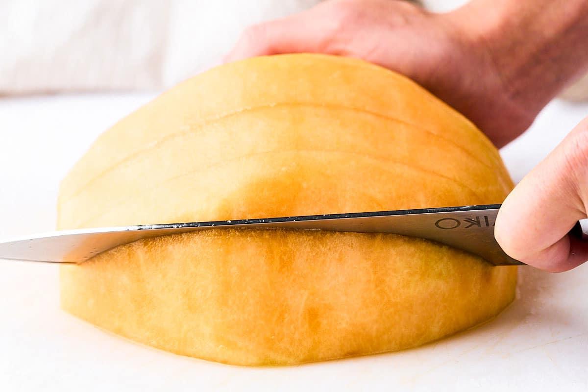 Eine Kantalupemelone in Spalten schneiden.