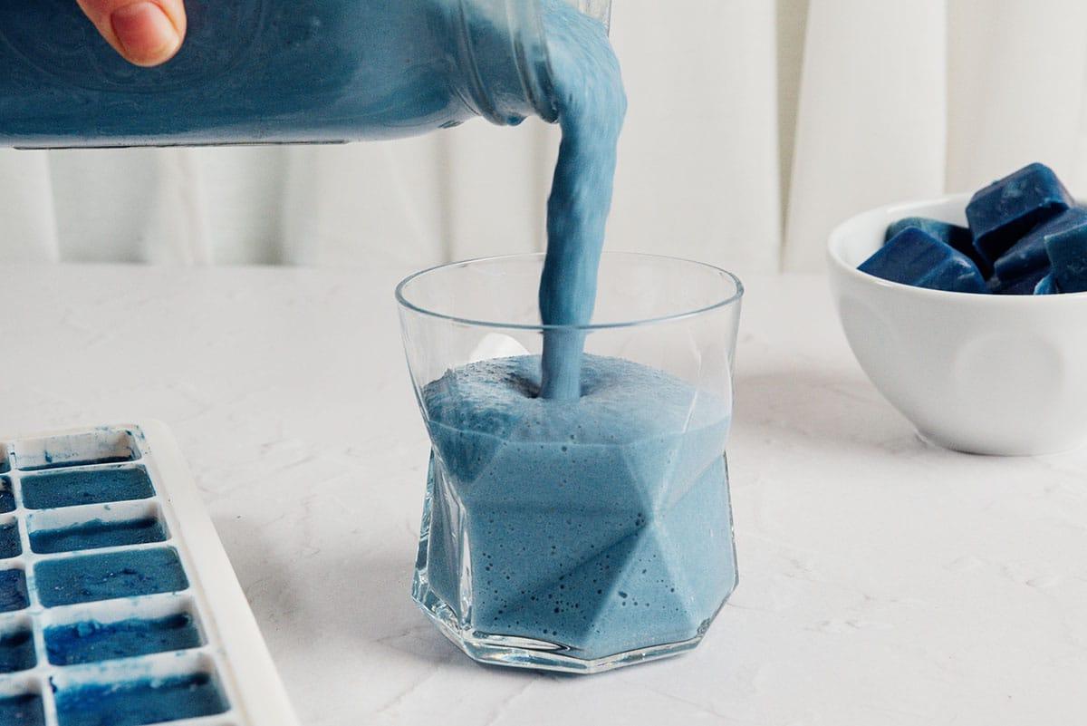 Ein blauer Smoothie in einem Glas, fertig zum Trinken.