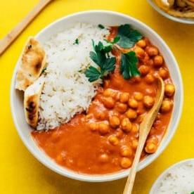 Veganes Tikka Masala mit Naan und Reis in einer weißen Schüssel.