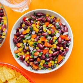 Bohnensalat in einer Schüssel auf orangefarbenem Hintergrund