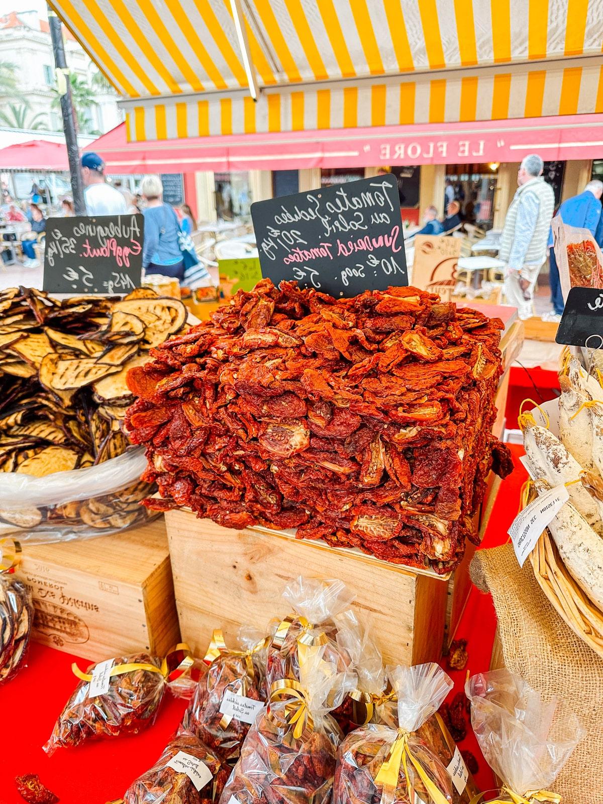 Ein Feinschmecker in Frankreich 20 Lebhafter Marktstand mit frischen Produkten, darunter bunte Gemüse und Obst, an einem sonnigen Tag.