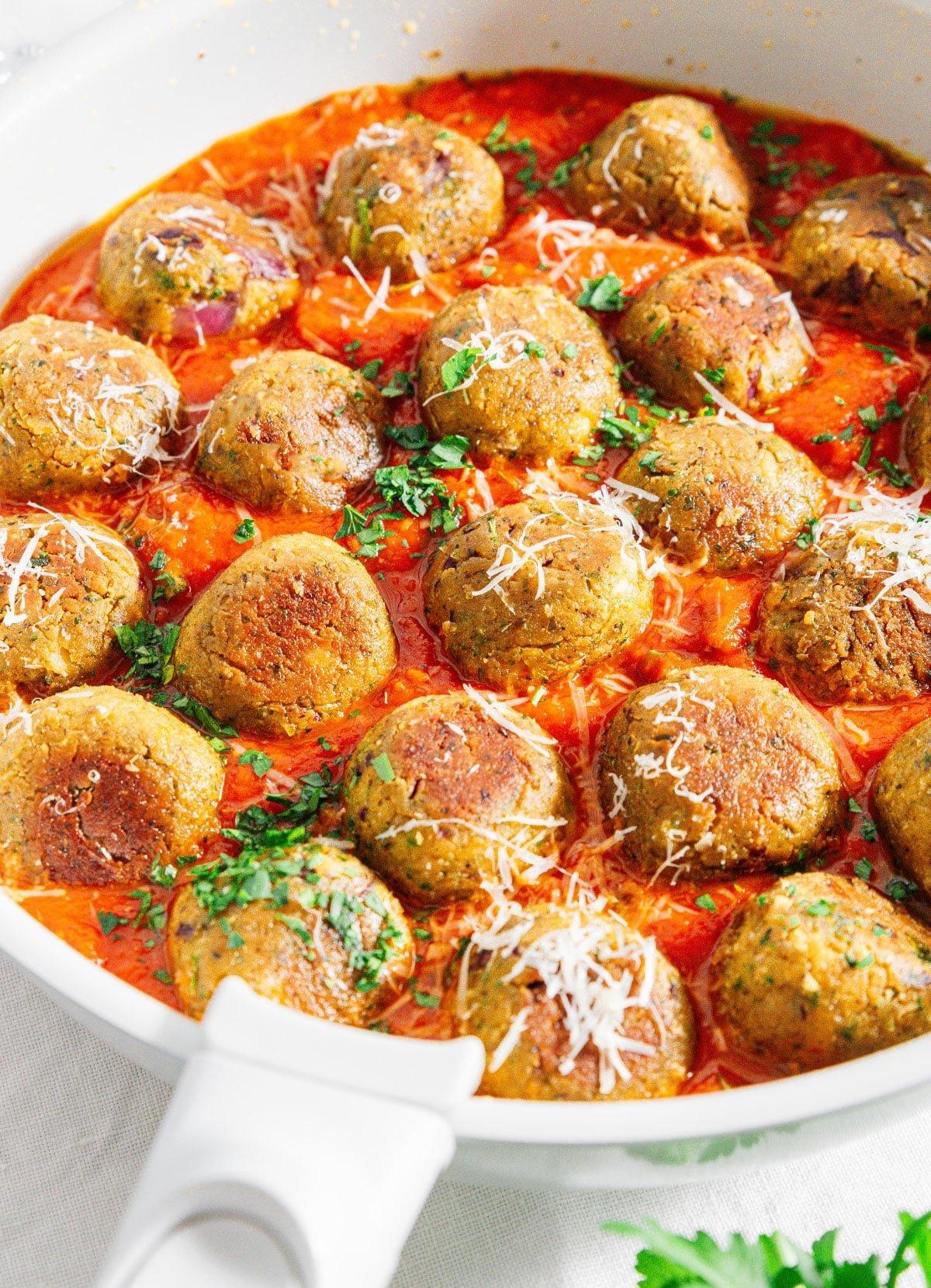 30-Minuten-Kichererbsen-Bällchen 3 Kichererbsenfrikadellen in einer Pfanne mit Marinara-Sauce.
