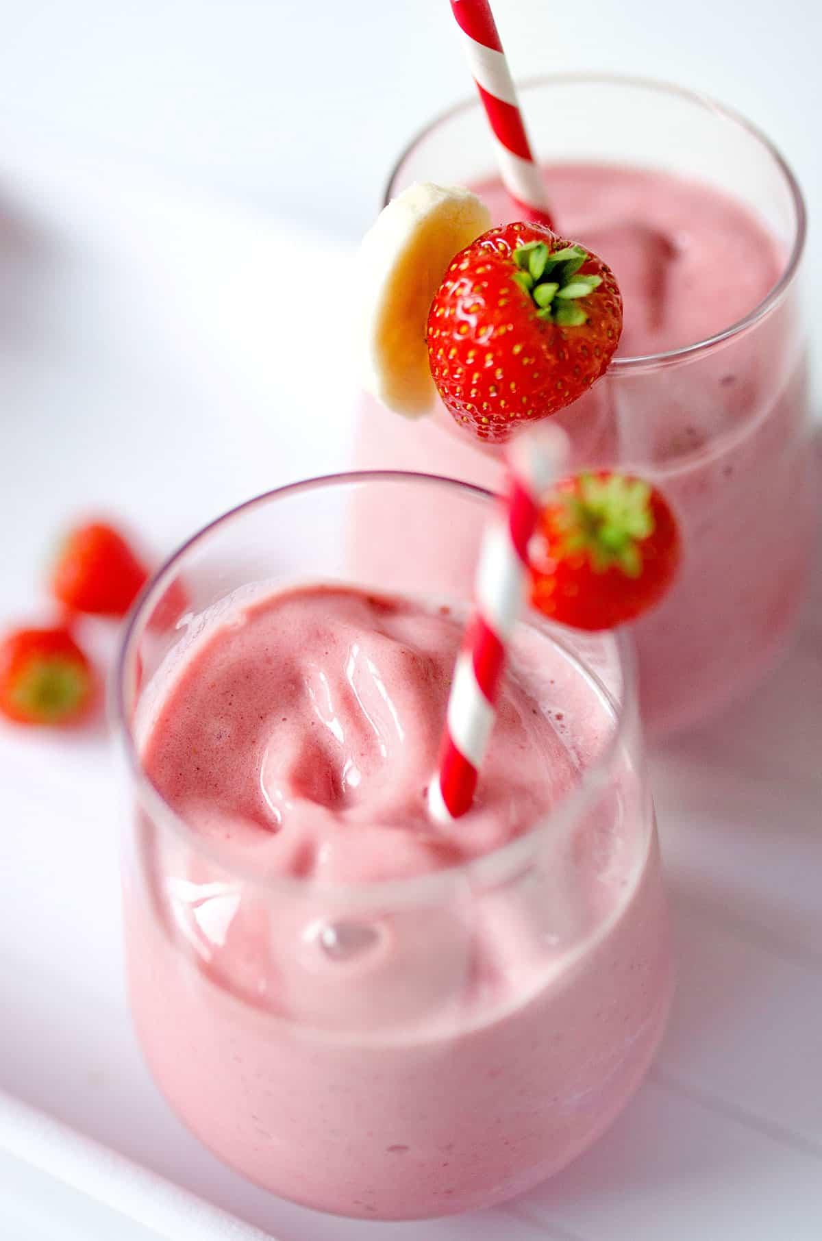 Erdbeer-Bananen-Smoothie (3 Zutaten) 3 Erdbeer-Bananen-Smoothie in einem Glas mit Strohhalm, von oben gesehen.