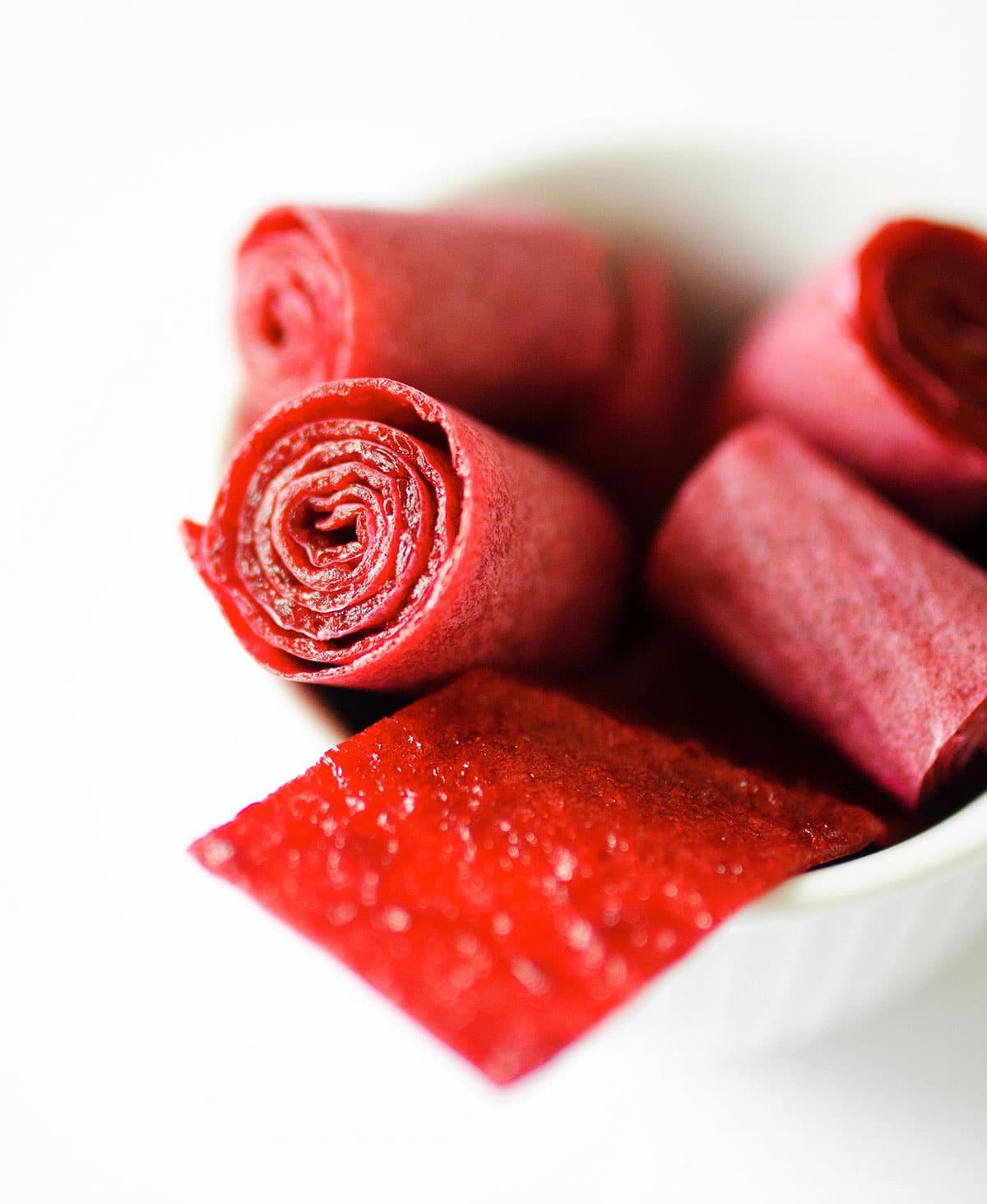 Gesunde selbstgemachte Fruchtleder 3 Frucht-Roll-Ups in einer weißen Schüssel.