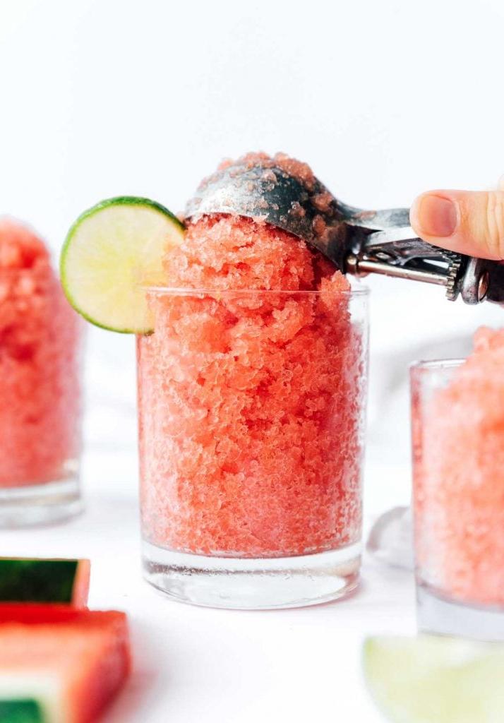 Einfache Wassermelonen-Granita 3 Wassermelonen-Granita mit einer Kelle in ein Glas schöpfen, daneben eine Limettenscheibe