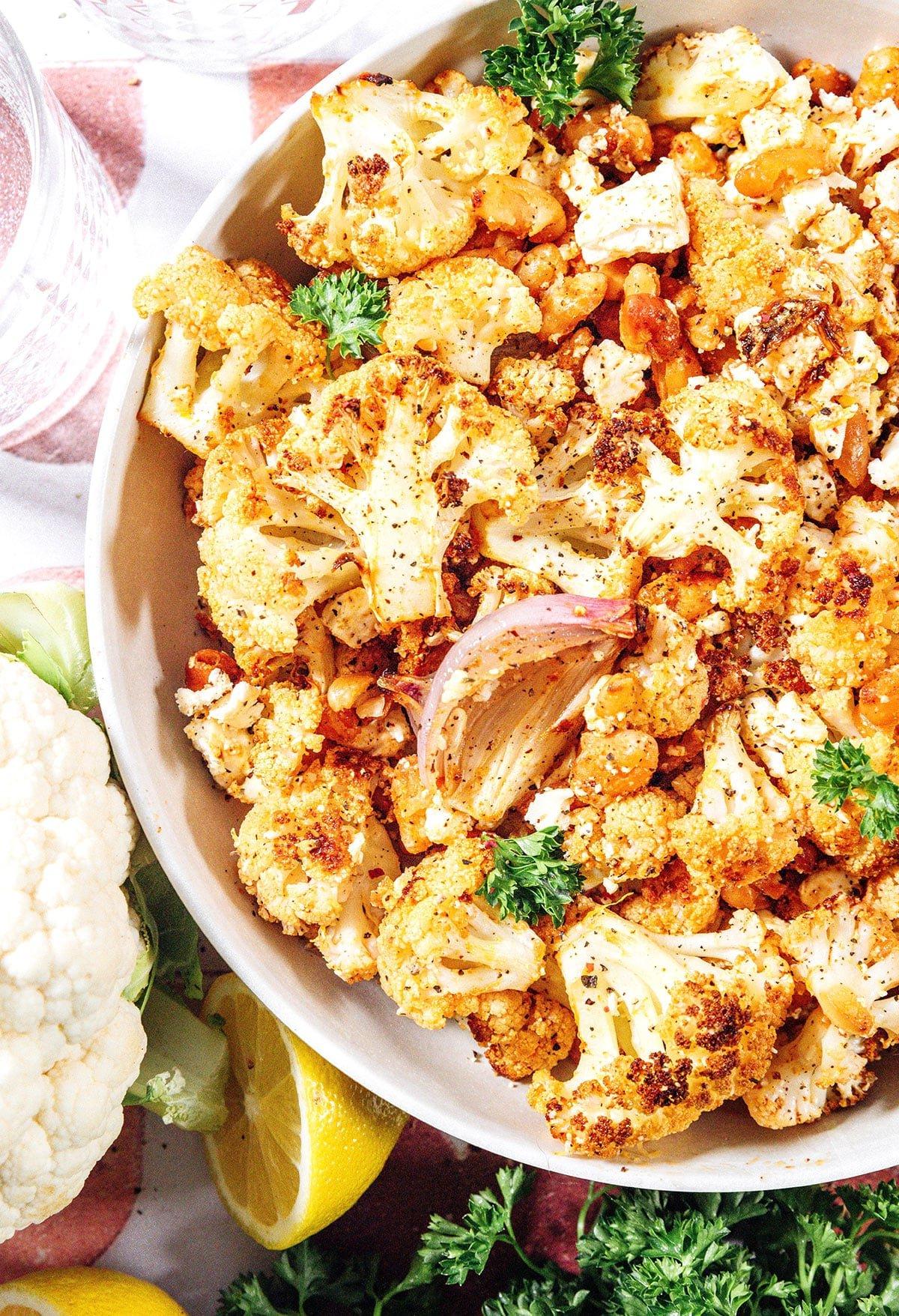 Gerösteter Blumenkohlsalat mit knusprigen Bohnen 3 Nahaufnahme eines gerösteten Blumenkohlsalats mit knusprigen Bohnen und Feta.