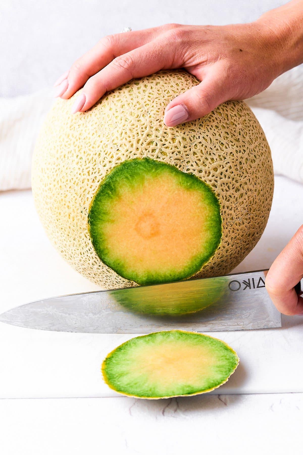 Wie man eine Cantaloupe schneidet (Ohne einen Finger zu verlieren!) 3 Das Ende der Kantalupemelone abschneiden.