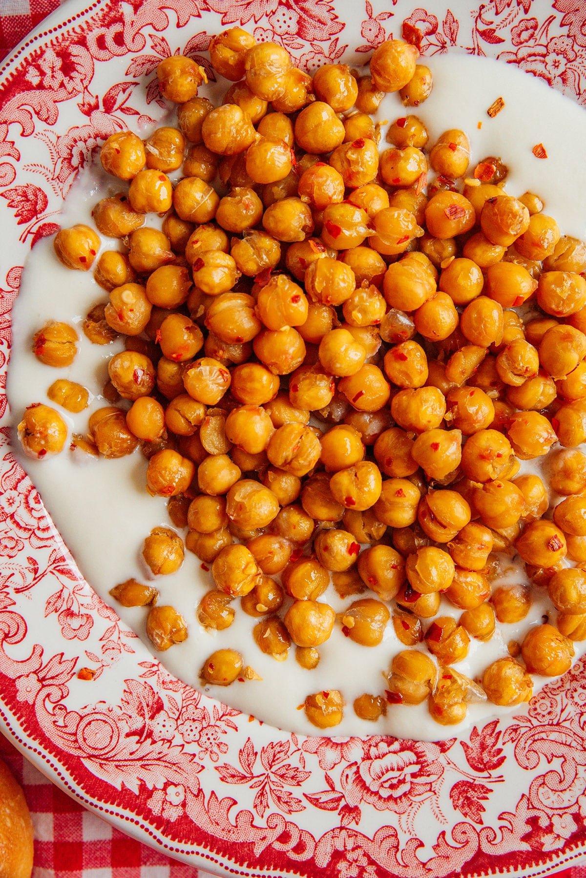 Geröstete Kichererbsen mit Chili-Honig und Aufgeschlagenem Feta 3 Hot Honey Kichererbsen mit cremigem Feta-Dip auf einer Platte.
