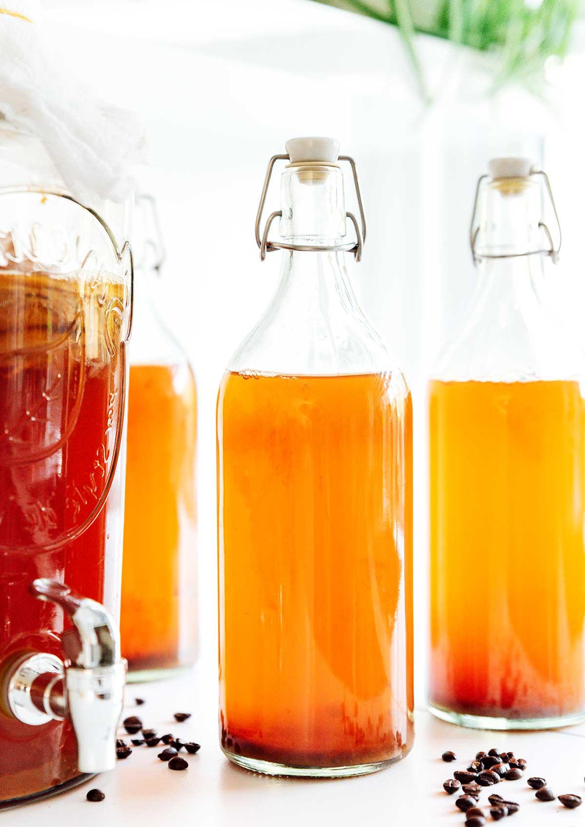 Kaffee-Kombucha 3 Kaffee Kombucha in Fermentationsflaschen auf weißem Hintergrund