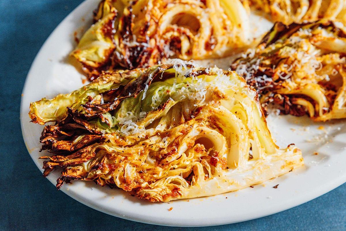 Einfacher Heißluftfritteusen-Kohl 3 Kohlspalten aus der Heißluftfritteuse auf einer Platte angerichtet.