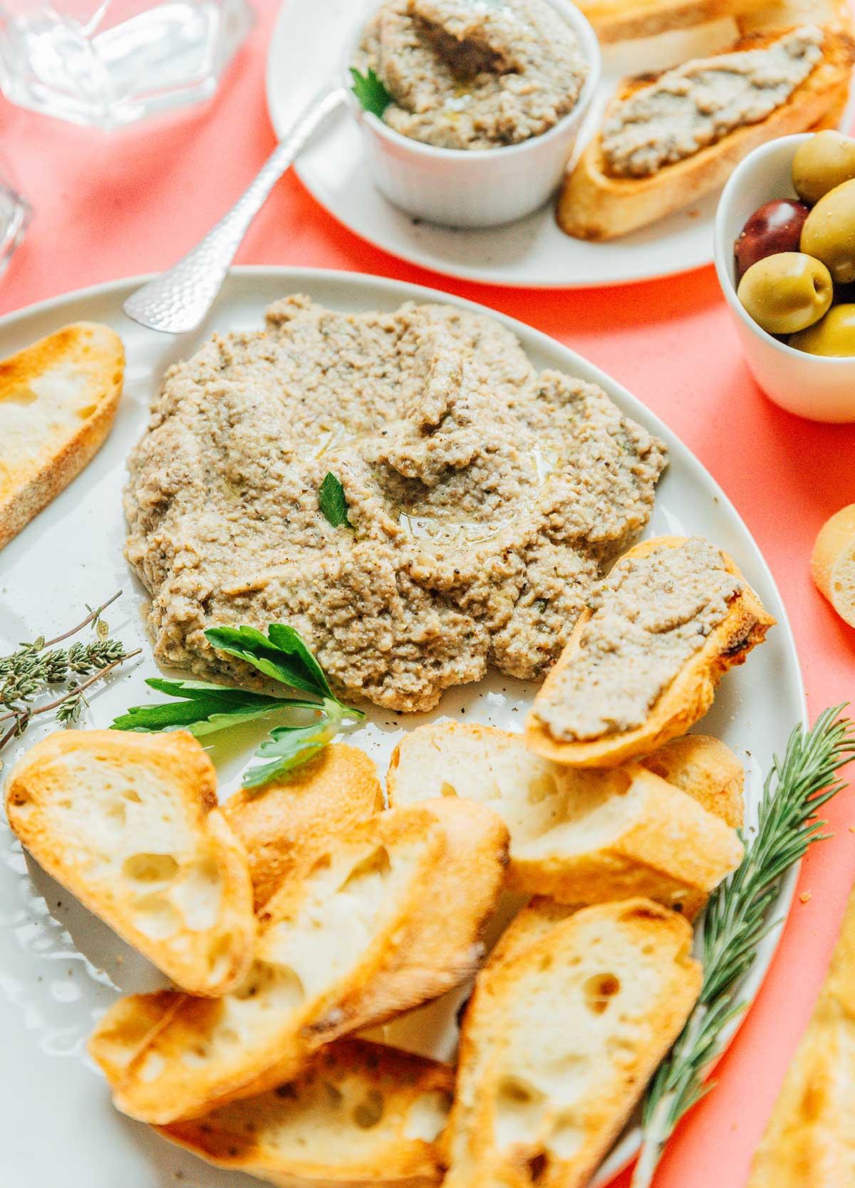 Pilzpastete 3 Ein großer Klecks Pilzpastete auf einem weißen Teller mit Scheiben von französischem Brot
