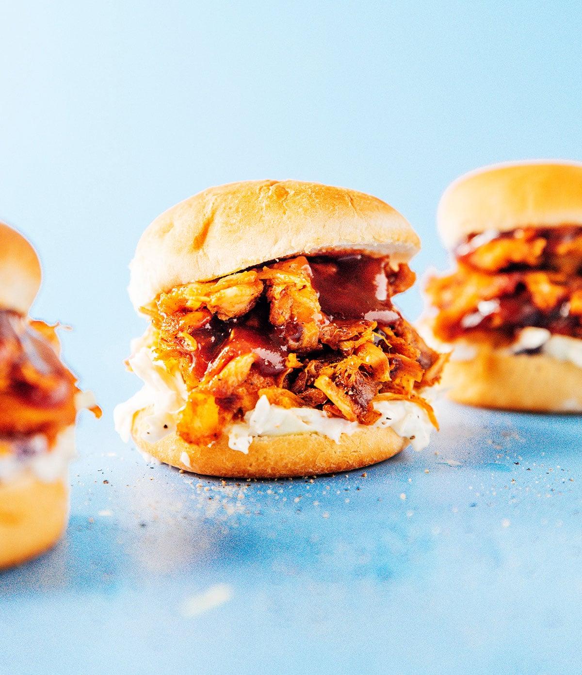 BBQ Jackfrucht Pulled Pork (Fertig in 30 Minuten) 3 Ein Detailbild eines BBQ Jackfrucht Sliders mit Krautsalat und heruntertropfender BBQ-Sauce.