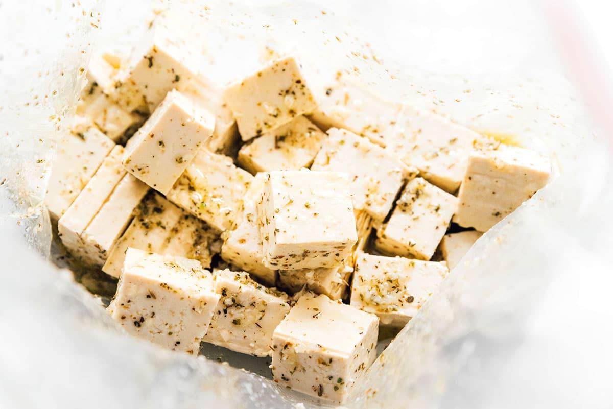 Wie man Tofu mariniert (8 Geschmacksrichtungen!) 23 Knoblauch- und Kräutermarinade mit Tofu-Würfeln in einem Beutel.