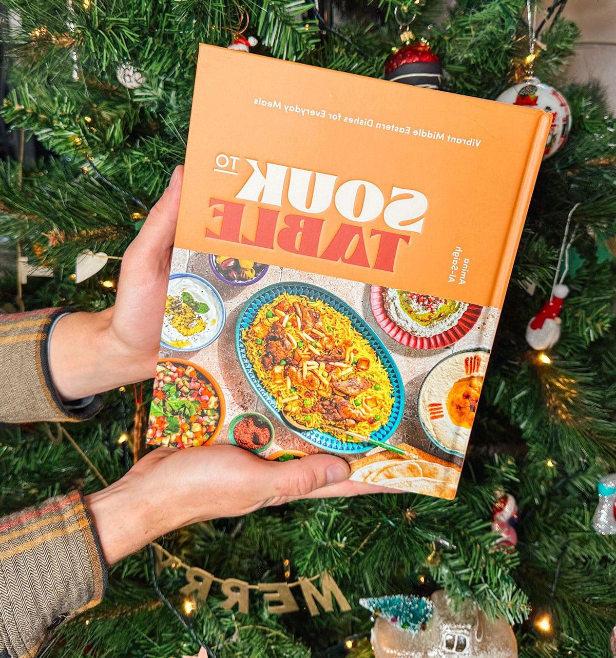 Das Kochbuch 'Souk to Table' als Geschenk vor einem Weihnachtsbaum.