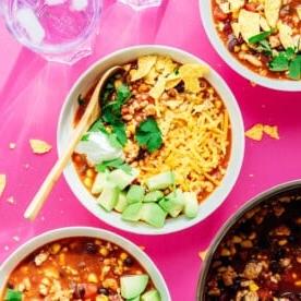 Taco soup in a bowl on a pink background