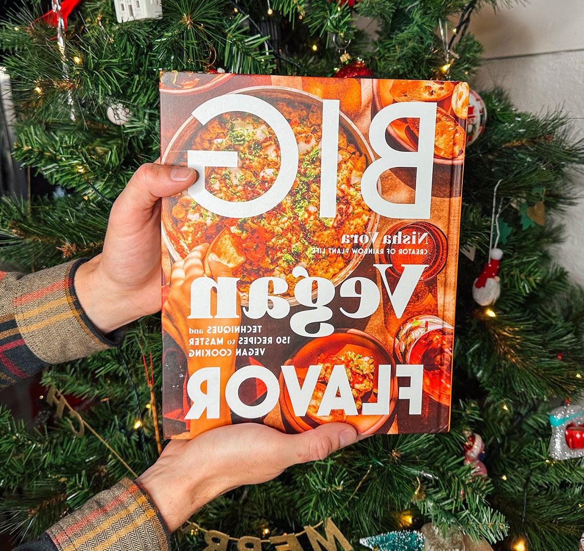 Das Kochbuch 'Big Vegan Flavor' als Geschenk vor einem Weihnachtsbaum.
