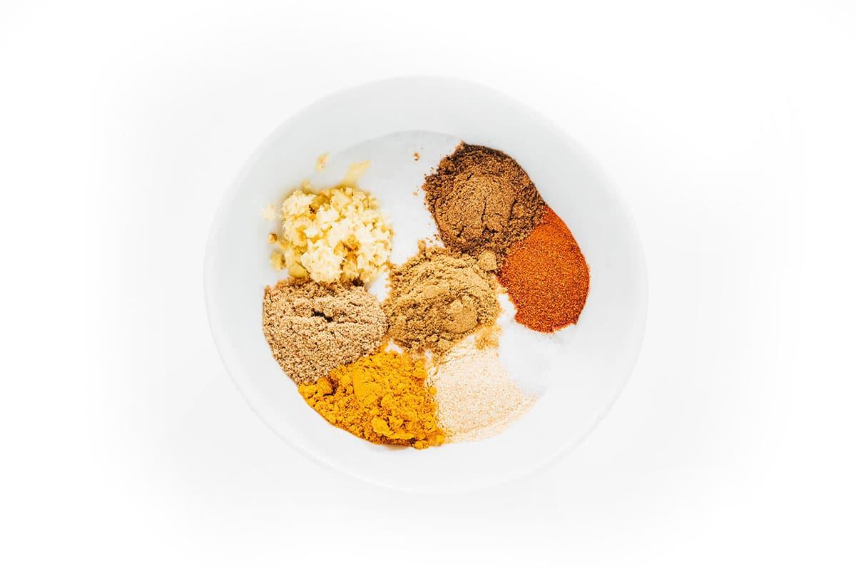 Wie man Tofu mariniert (8 Geschmacksrichtungen!) 25 Tandoori-Gewürze in einer kleinen weißen Schüssel.