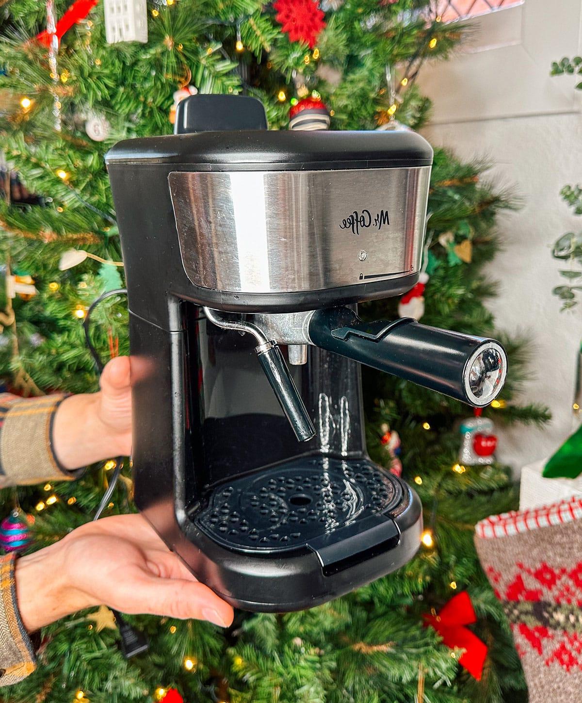 Eine Mr. Coffee Espressomaschine als Geschenk vor einem Weihnachtsbaum.