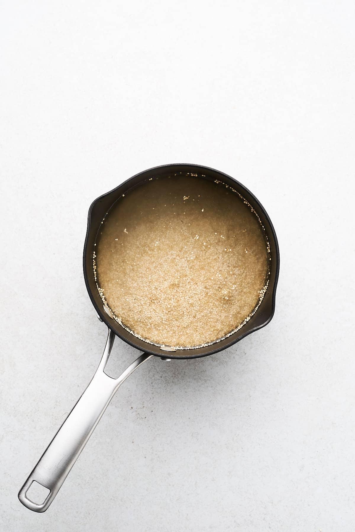 Quinoa kochen (Gelingsicheres Rezept) 4 Ungekochter Quinoa und Wasser in einem Topf