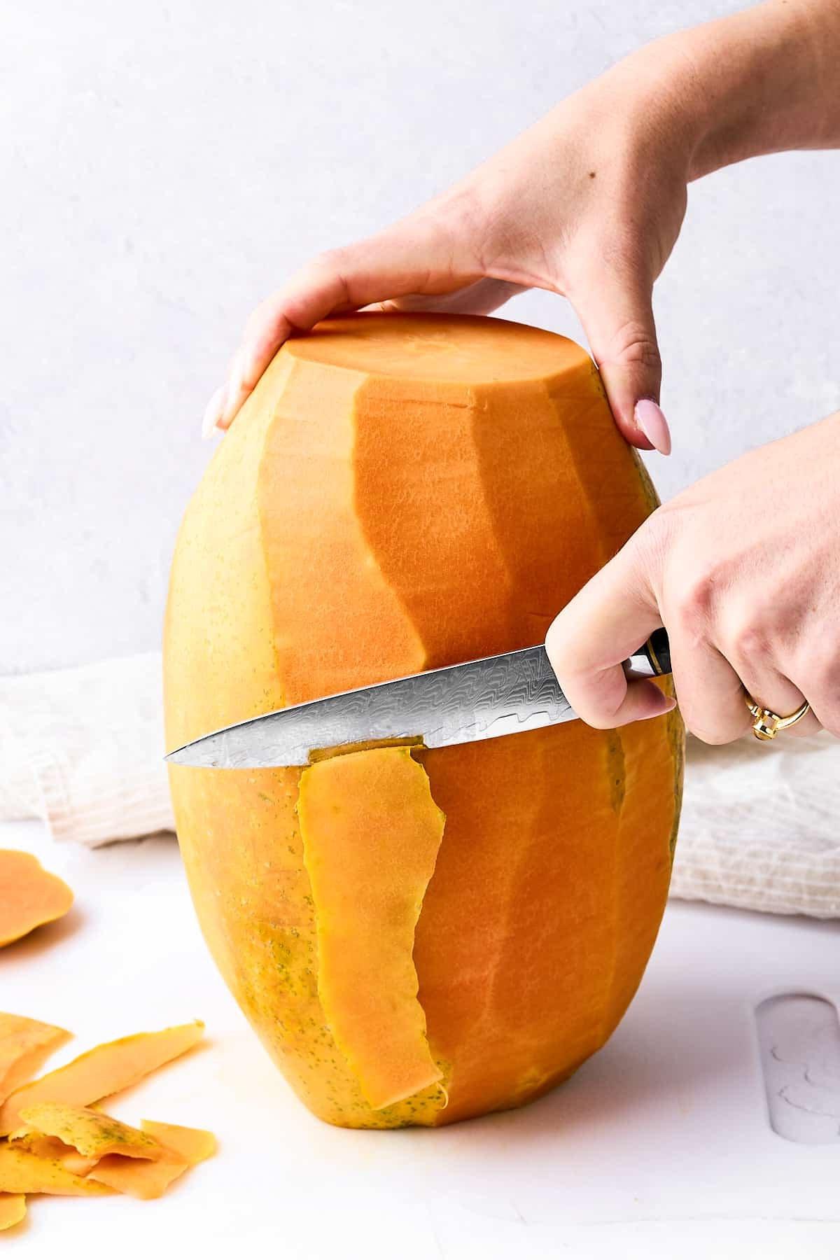 Papaya schneiden 4 Eine Papaya mit einem Schälmesser schälen.