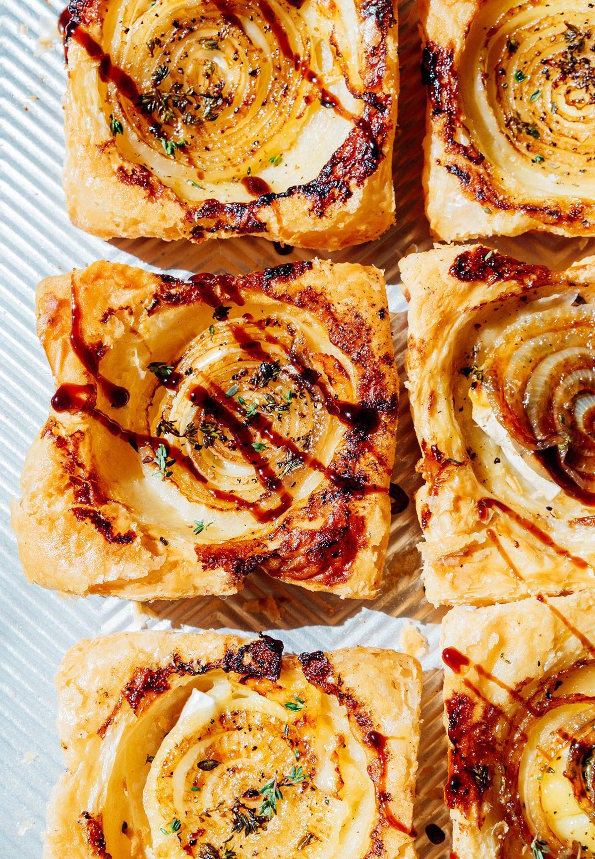 **Gestürzte Zwiebeltarte mit Brie** 4 Zwiebeltarte auf einem Teller.