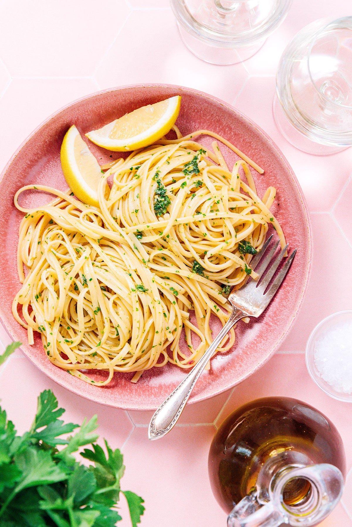 Zitronige Gremolata Pasta (Fertig in 15 Minuten) 4 Eine rosa Schüssel gefüllt mit Gremolata Pasta und zwei Zitronenspalten