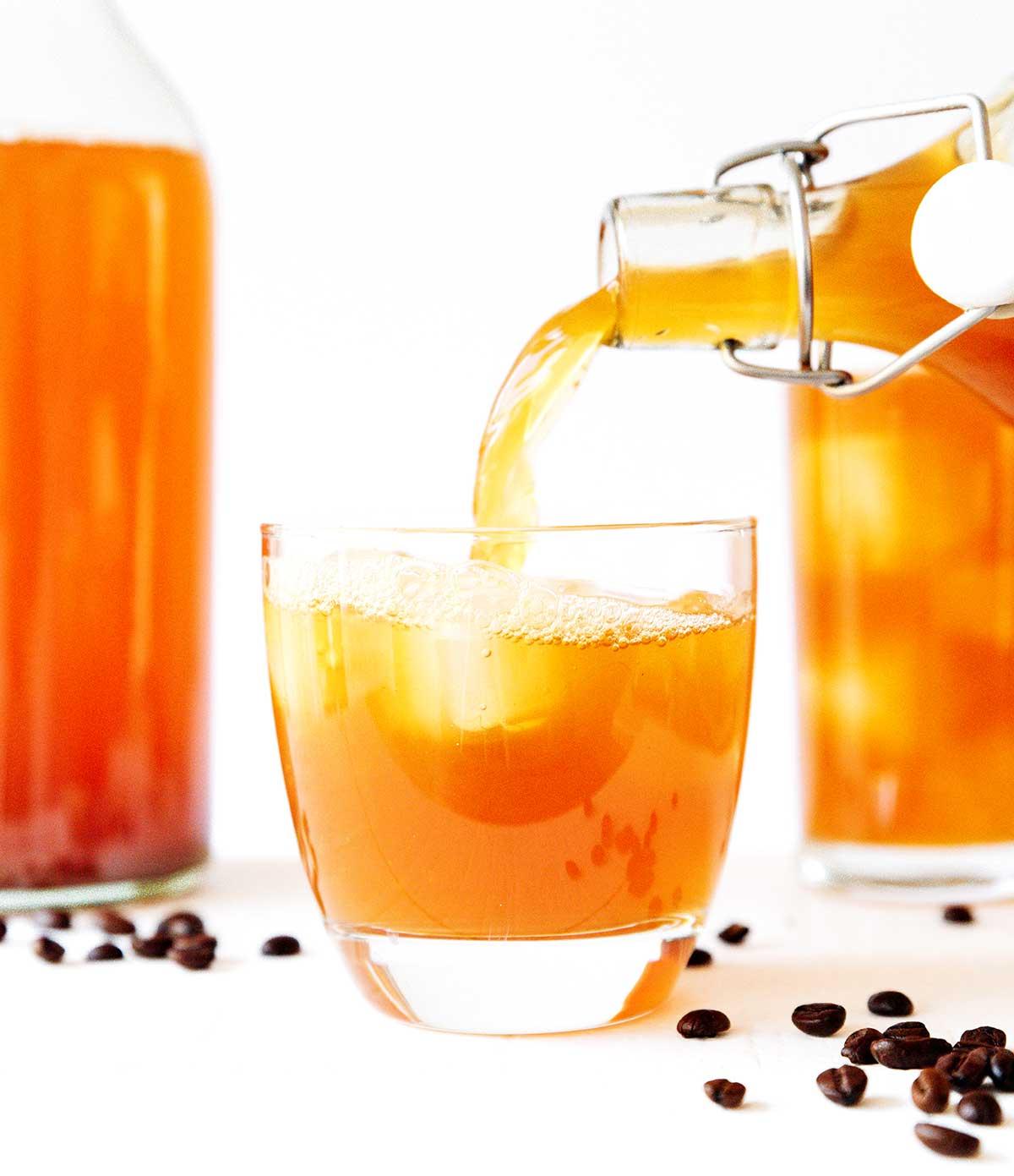 Kaffee-Kombucha 4 Kaffee Kombucha in ein Glas mit Eis gießen