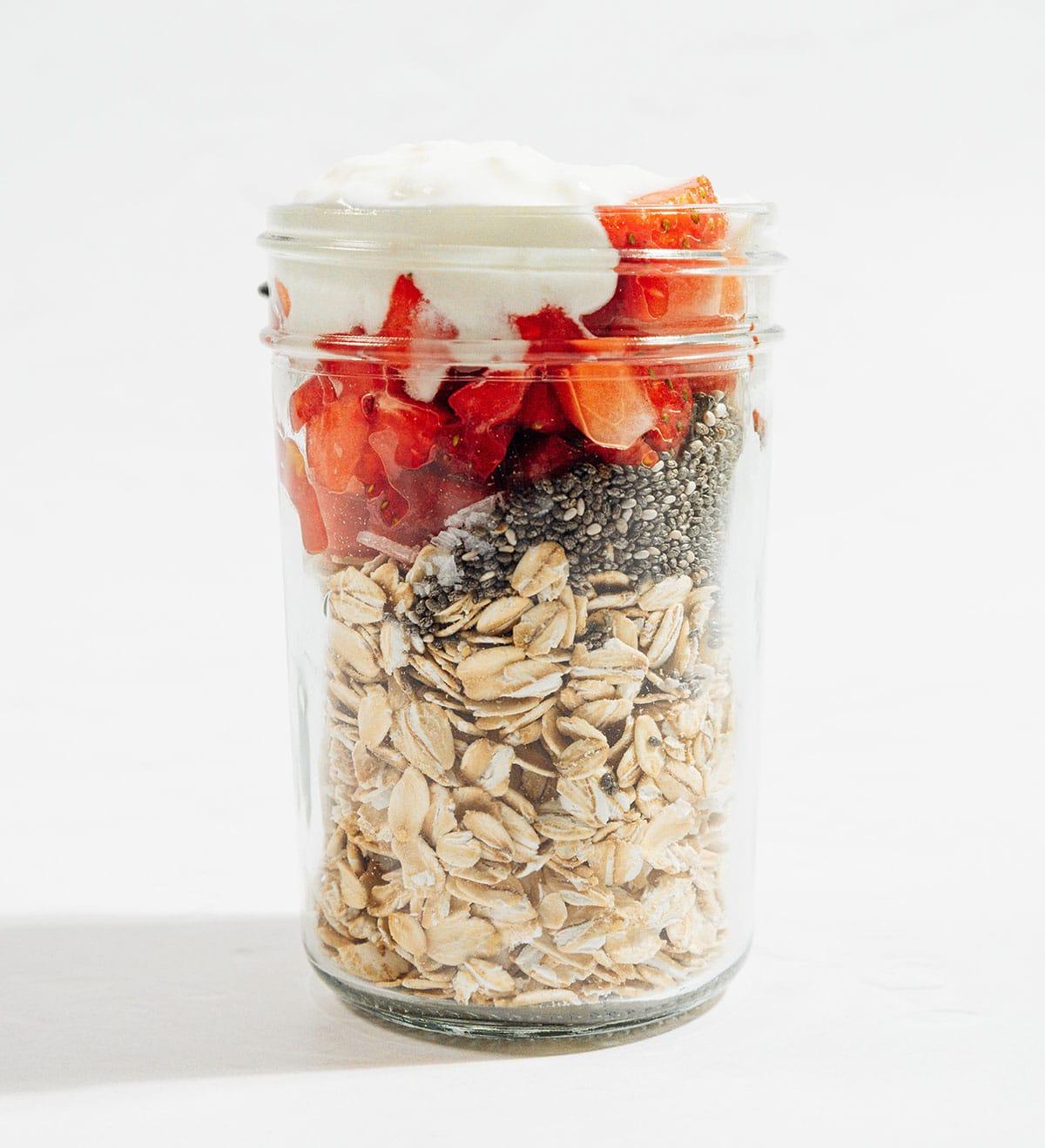 Cremige Erdbeer Overnight Oats (5 Minuten) 4 Alle Zutaten für Erdbeer Overnight Oats in einem Glas angeordnet.