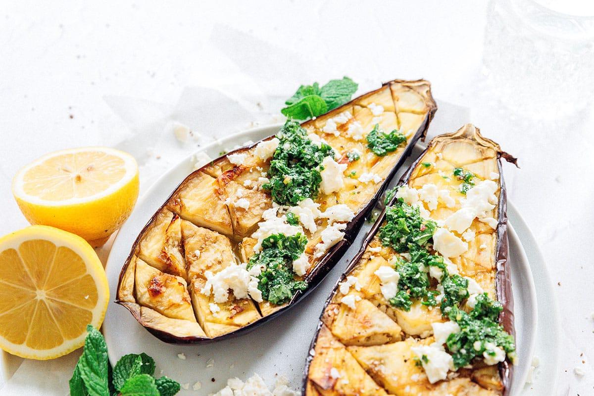 Geröstete Aubergine mit Feta-Minz-Soße 4 Geröstete Aubergine aufgeschnitten mit Feta und Minze.
