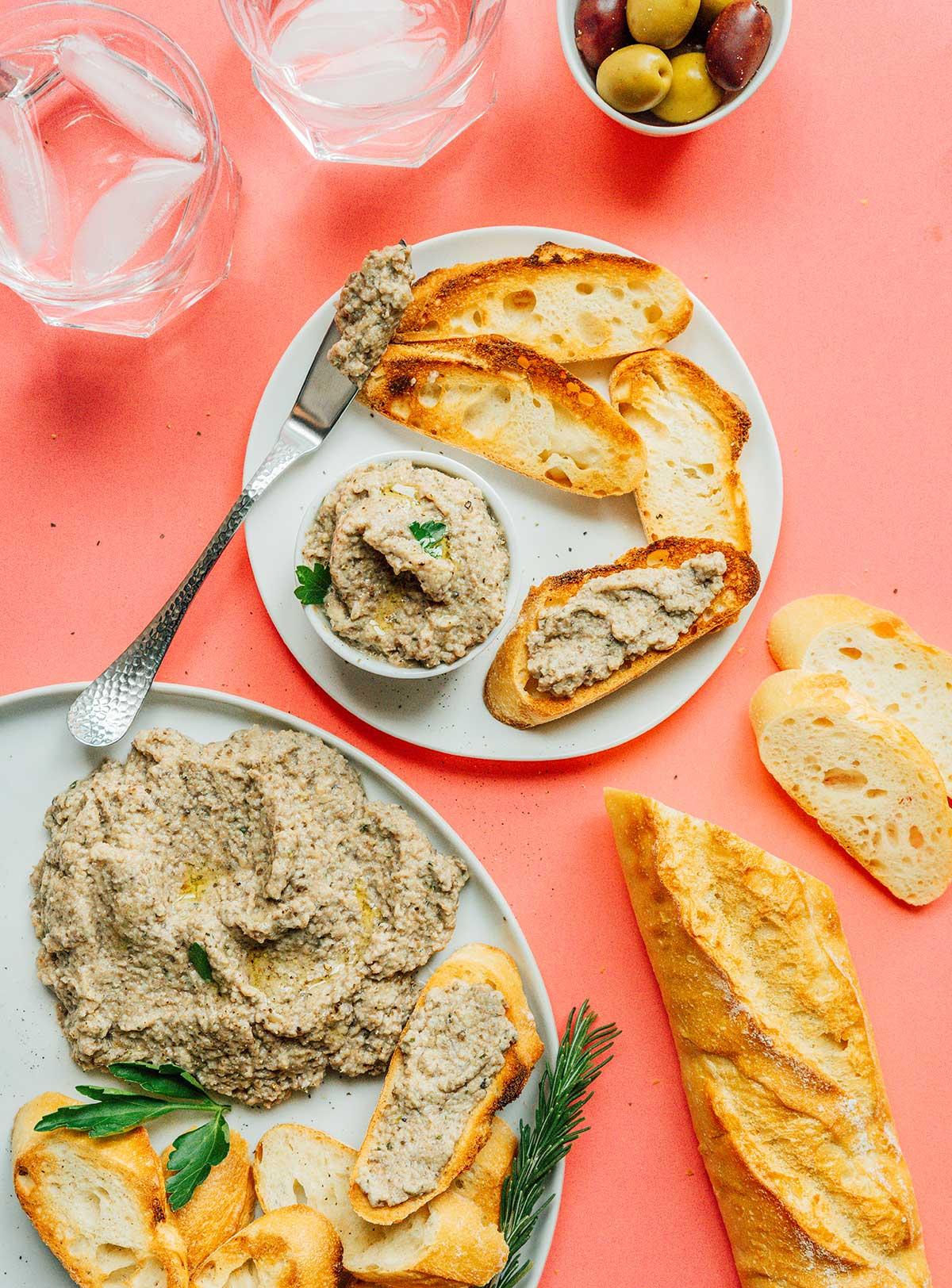 Pilzpastete 4 Eine kleine Schale Pilzpastete auf einem weißen Teller mit Scheiben von französischem Brot