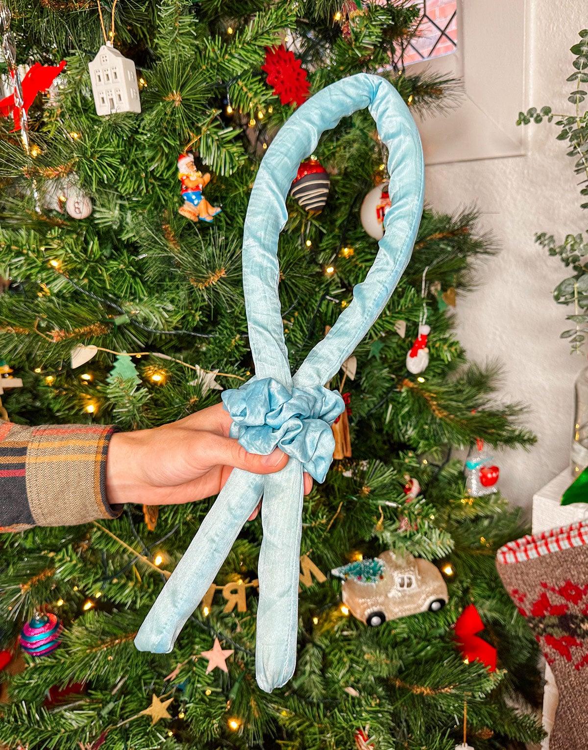 Hitze-freie Lockenwickler als Geschenk vor einem Weihnachtsbaum.