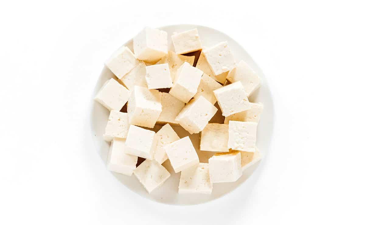 Wie man Tofu mariniert (8 Geschmacksrichtungen!) 5 Schlichte Tofu-Würfel in einer weißen Schüssel.