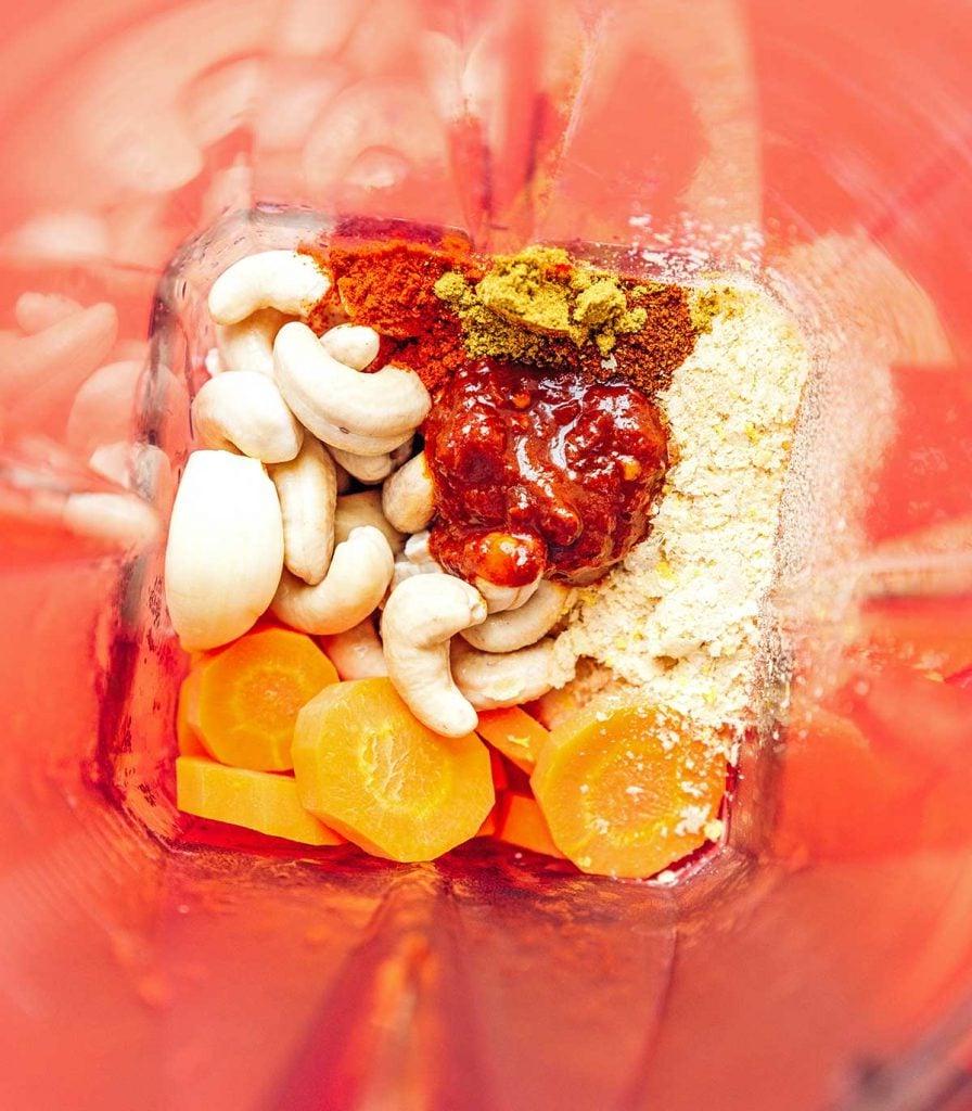 **10-Minuten-Rezept für veganen Queso** 5 Vogelperspektive eines Glasmixers, gefüllt mit den ungemischten veganen Queso-Zutaten, bereit zum Mixen.