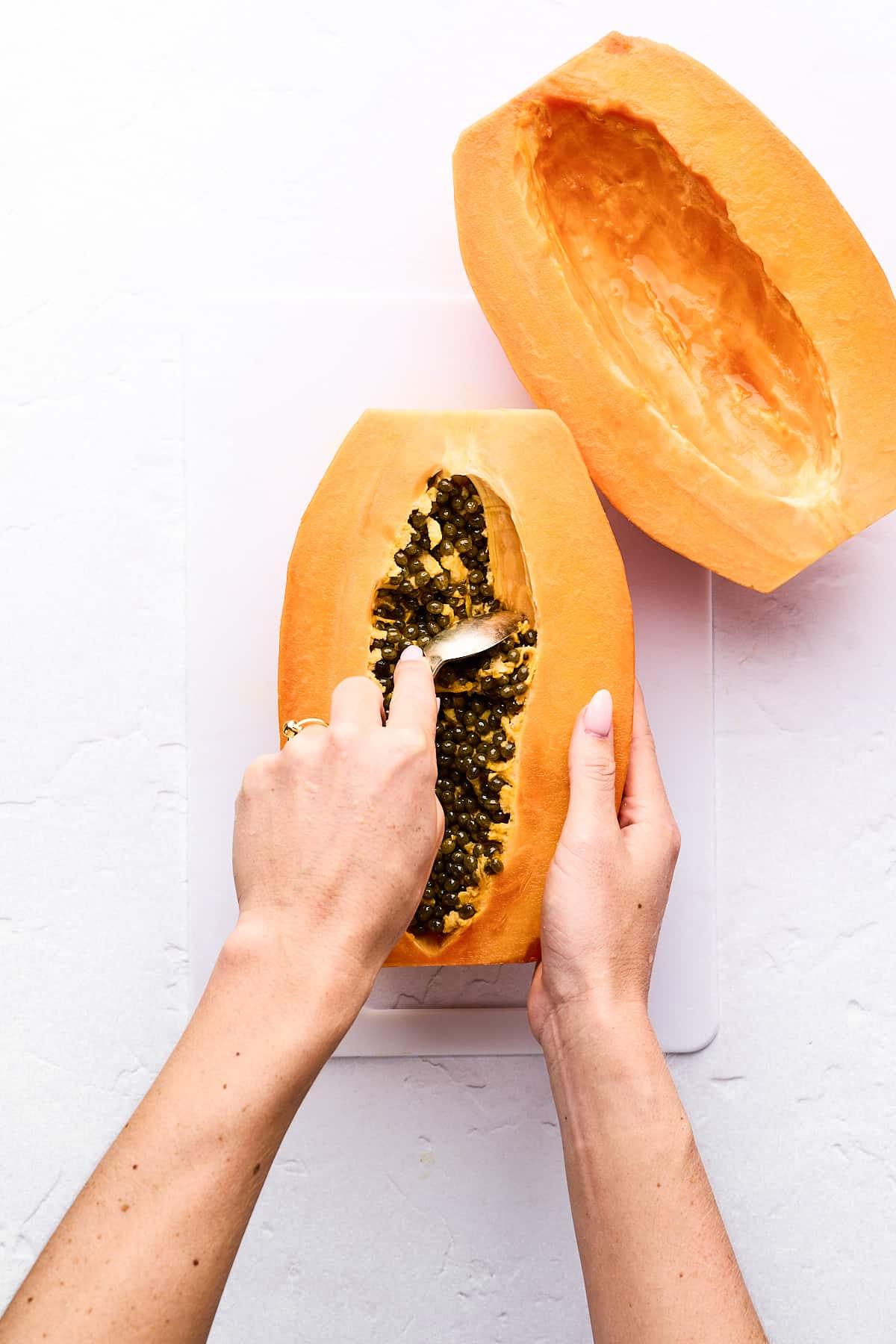 Papaya schneiden 5 Kerne aus einer Papayahälfte schöpfen.